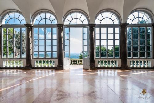 an empty room with large windows and a floor at Villa Guinigi Dimora di Epoca Exclusive Residence & Pool in Lucca