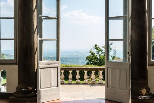 an open door to a balcony with a view at Villa Guinigi Dimora di Epoca Exclusive Residence & Pool in Lucca