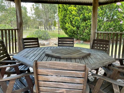 a wooden table and chairs on a deck at Crows Nest Motel in Crows Nest