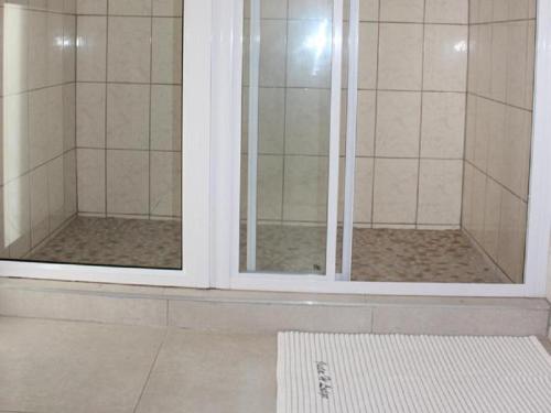 a shower with two glass doors in a bathroom at Juda Haus Lodge in Katima Mulilo