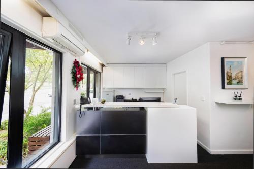 a kitchen with white cabinets and a large window at Comfort Hotel East Melbourne in Melbourne