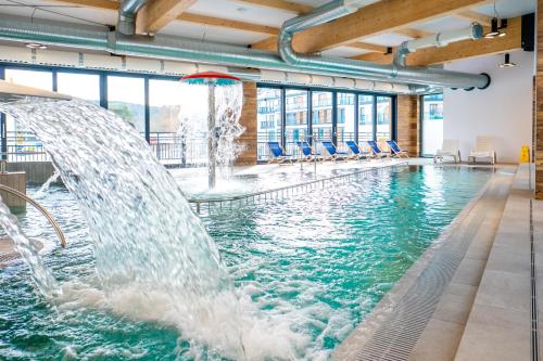 una piscina con getti d'acqua in un edificio di Bel Mare Resort a Międzyzdroje