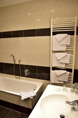 a bathroom with a sink and a bath tub and a sink at Hotel Krone in Brunico