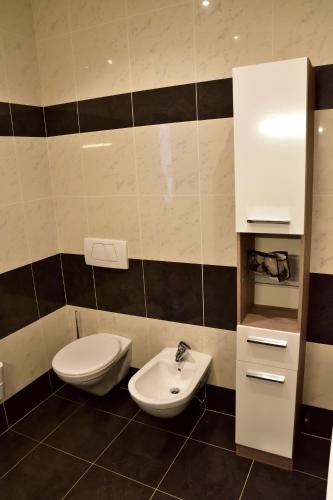 a bathroom with a toilet and a sink at Hotel Krone in Brunico