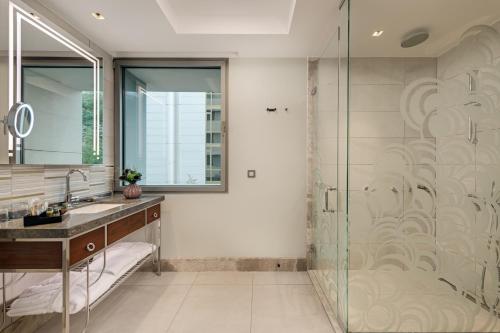 a bathroom with a glass shower and a sink at The Artisan Hotel Istanbul - MGallery Collection in Istanbul