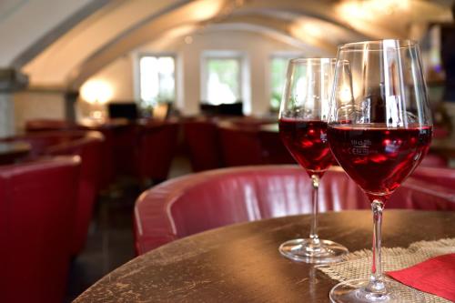 two glasses of red wine sitting on a table at Hotel Krone in Brunico