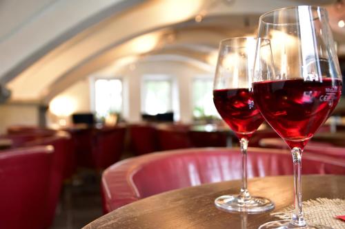 two glasses of red wine sitting on a table at Hotel Krone in Brunico