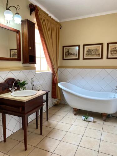 baño con bañera grande y lavamanos en Kimberley Club Guesthouse en Kimberley