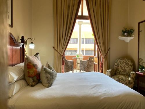a bedroom with a large bed and a window at Kimberley Club Guesthouse in Kimberley