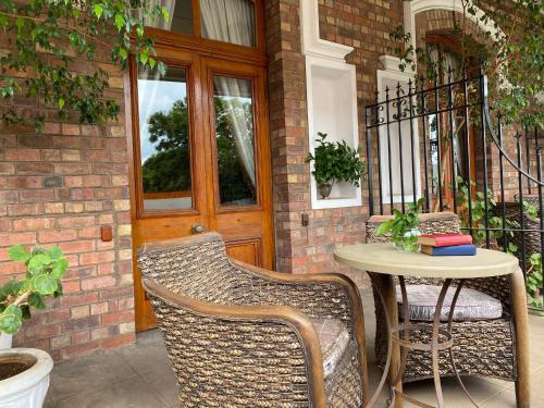 a patio with a table and chairs in front of a door at Kimberley Club Guesthouse in Kimberley