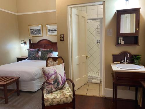 a bedroom with a bed and a bathroom with a sink at Kimberley Club Guesthouse in Kimberley