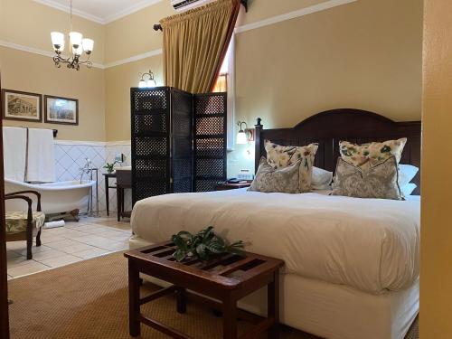 1 dormitorio con 1 cama y baño con bañera en Kimberley Club Guesthouse en Kimberley