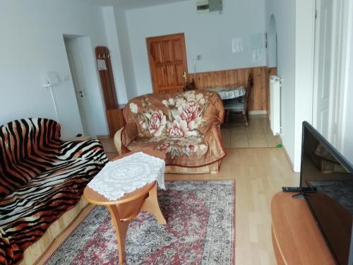 a living room with a couch and a chair at Horváth Apartman in Cserkeszőlő