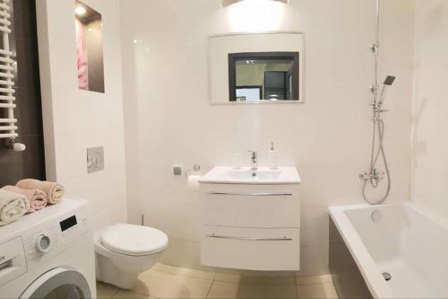 a white bathroom with a toilet and a sink at Luxury KINGS RESIDENCE 50m2 2 pok. Downtown Dobrego Pasterza PIĘKNY in Kraków