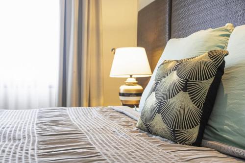 a bedroom with a bed with a pillow and a lamp at ZEN AT THE ESPLANADE - Spectacular Sunset Retreat in Darwin