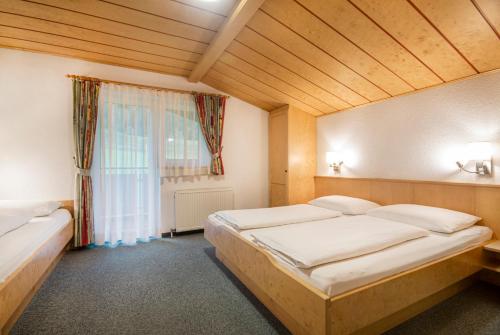 a bedroom with two beds and a window at Apartpension Kappacher in Kaprun
