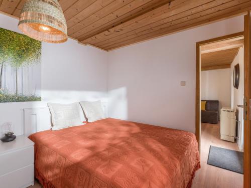 a bedroom with a bed with a orange bedspread at Grabner Riedleiten in Oberaudorf