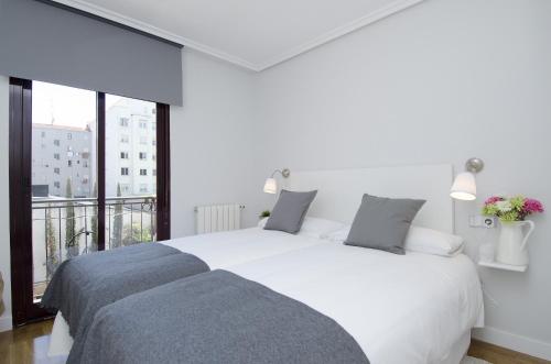 een witte slaapkamer met een groot bed en een balkon bij Apartamento Salamanca VI en Madrid in Madrid