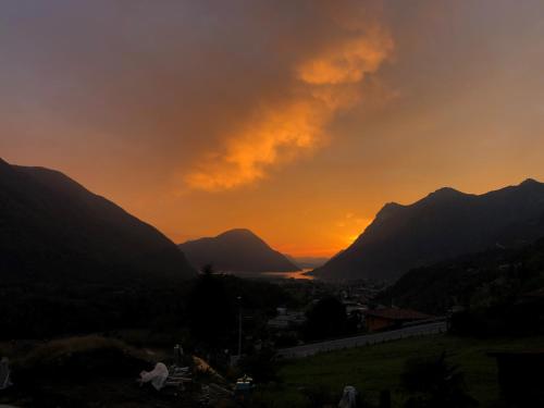 een zonsondergang in de bergen met een stad en een stad bij B&B Gli Ulivi in Carlazzo