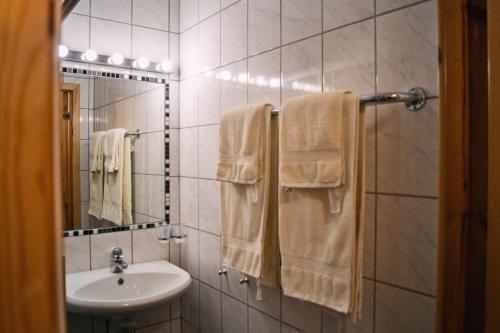 een badkamer met een wastafel, een spiegel en handdoeken bij Drei Jahreszeiten in Bredsatra