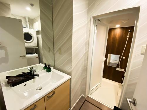 a small bathroom with a sink and a mirror at Bears Stay Kumejima Eef Beach in Kumejima