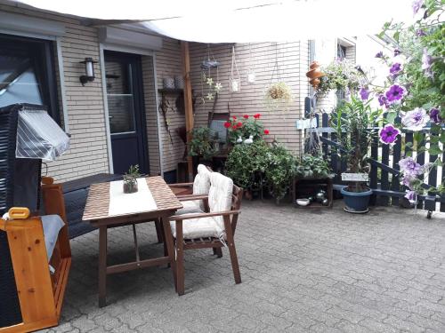 a patio with a table and chairs and flowers at XXS Appartement Junghans in Silberstedt