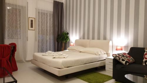 ein weißes Schlafzimmer mit einem weißen Bett und einem Sofa in der Unterkunft B&B AMAVERONA in Verona