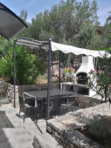 a patio with a table and chairs and an umbrella at apartman-maja-krk in Krk