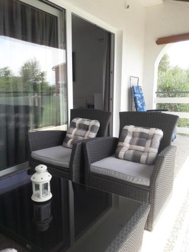 two chairs and a table on a screened porch at apartman-maja-krk in Krk