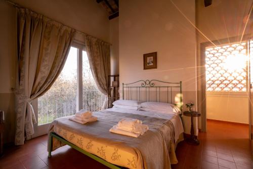 a bedroom with a bed and a large window at Il Pignocco Country House in Santa Veneranda