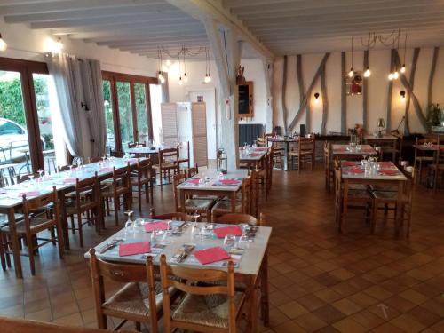 une salle à manger avec de nombreuses tables et chaises dans l'établissement La Taverne, à Buire-le-Sec
