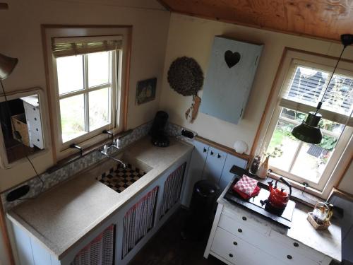 einen Blick über eine Küche mit zwei Fenstern in der Unterkunft Zoute Bries, in Natuurgebied en vlakbij het Strand in Callantsoog