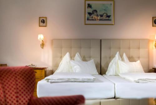 a hotel room with two beds with white pillows at Vergeiner's Hotel Traube in Lienz