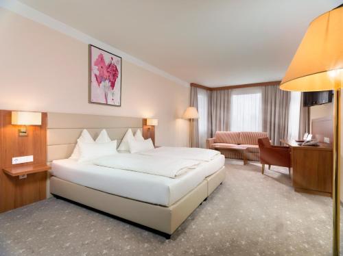 a hotel room with a bed and a living room at Vergeiner's Hotel Traube in Lienz
