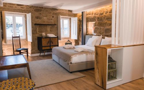 Casa da Ana Boutique Guest House في بارسيلوس: غرفة نوم بسرير وطاولة وكراسي