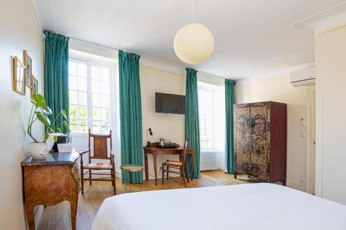 a bedroom with a bed and a table and chairs at Hôtel Restaurant De La Poste & Du Lion D'or in Vézelay