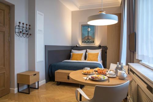 een kleine kamer met een bed en een tafel met eten erop bij STRADONIA Serviced Apartments in Krakau