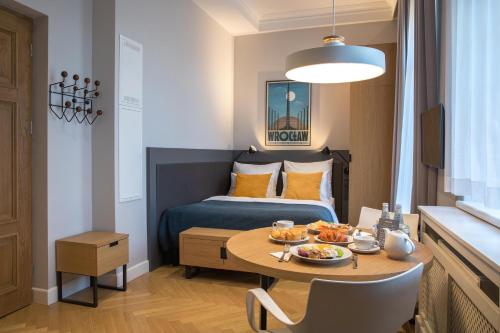 a small room with a bed and a table with food on it at STRADONIA Serviced Apartments in Krakow