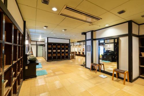 a large room with a library with wooden floors and chairs at Tabist Kinugawa Park Cottage in Nikko