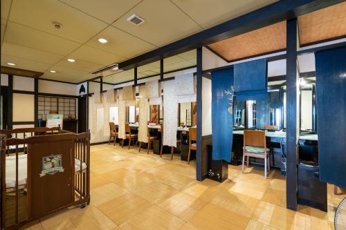 a dining room with blue walls and tables and chairs at Tabist Kinugawa Park Cottage in Nikko