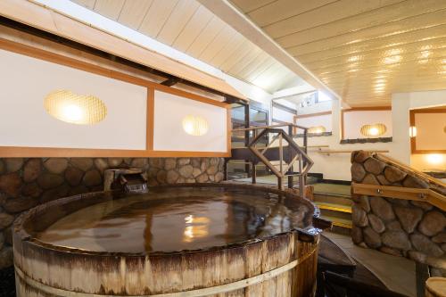 a hot tub in a barrel in a room with stairs at Tabist Kinugawa Park Cottage in Nikko