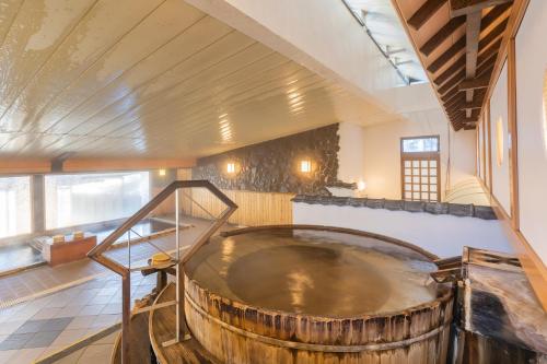 a large wooden tub in the middle of a room at Tabist Kinugawa Park Cottage in Nikko