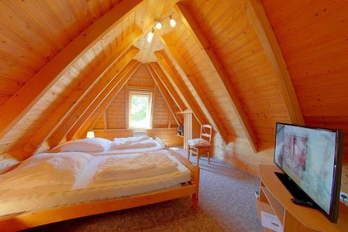 een slaapkamer met een bed op een houten zolder bij Strandvogt 2 MS6 in Dorum Neufeld