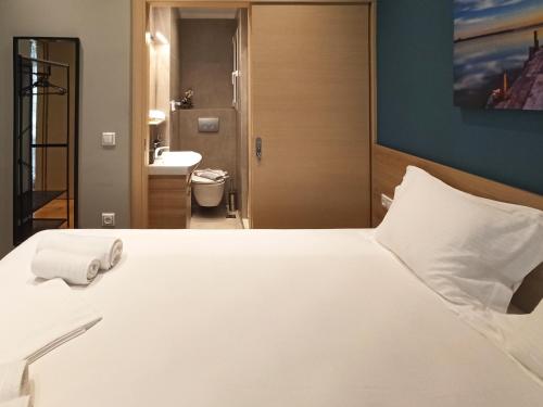 1 Schlafzimmer mit einem großen weißen Bett und einem Badezimmer in der Unterkunft Athens Sweet Home in Athen