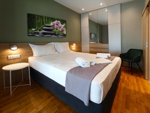 una camera d'albergo con un grande letto e una sedia di Athens Sweet Home ad Atene