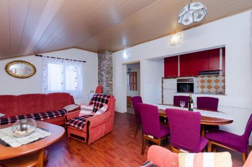 uma sala de estar com cadeiras vermelhas e uma mesa em Apartments Albina em Lopar