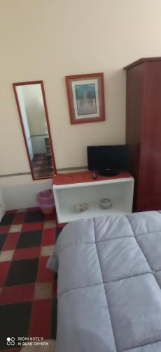 a bedroom with a bed and a desk with two mirrors at Casa Cristina in Siracusa