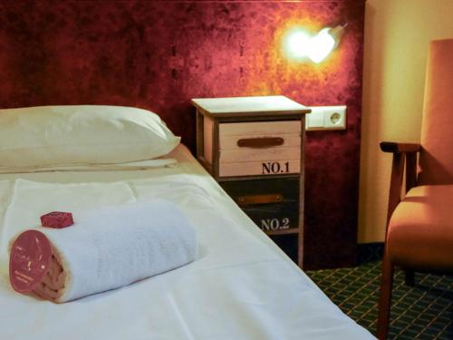a hotel room with a bed with a towel on it at Hafen 17 Hotel Küche Bar in Kehl am Rhein