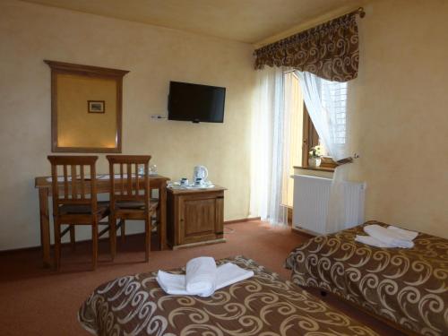 Una cama o camas en una habitación de Hotel Dwór Karolówka