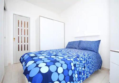 sypialnia z niebiesko-białą kołdrą na łóżku w obiekcie Appartamento Sul Mare w mieście Teulada